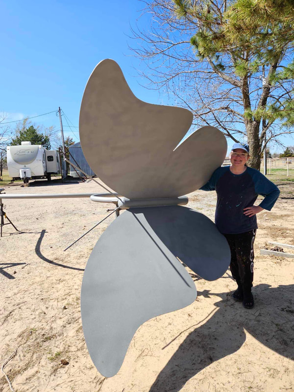 Kelly Tompkins standing next to the giant metal butterfly before it's painted