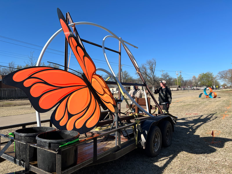 giant metal butterfly and arches loaded on a trailer to be installed