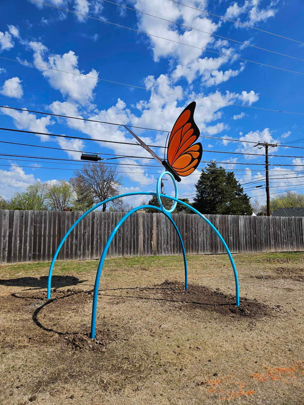 finished butterfly public art sculpture with a hoop and two arches